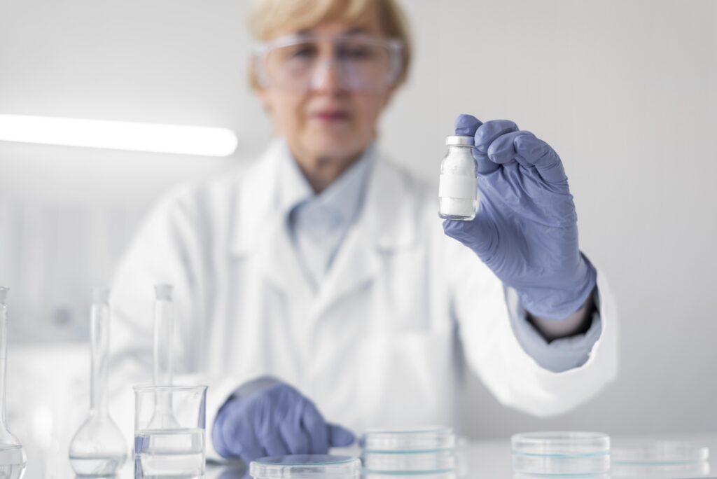 Scientist preparing glass vials for peptide reconstitution research in a modern laboratory.