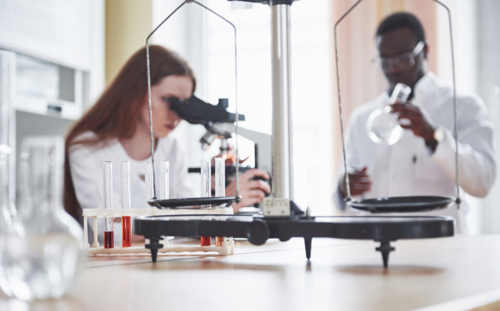 Two laboratory researchers in an analytical laboratory evaluating preclinical somatotroph signaling and growth hormone secretagogue receptor kinetics.