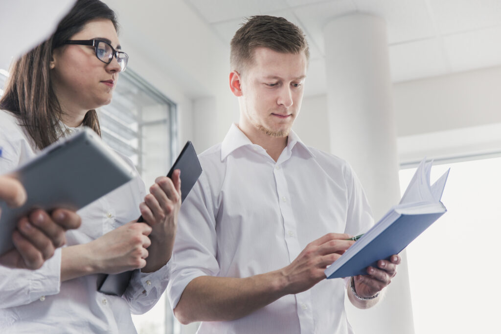 Reviewer examining printed technical documents, representing the FDA staff evaluation of peptide nominations described in the July 2026 briefing materials.